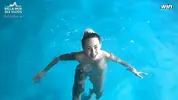 красиво плавает в бассейне голышом