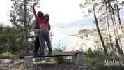 русские туристы шалят на лавке с видом на курортный город