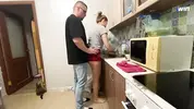пристает к девушке на кухне